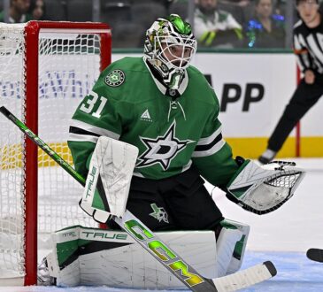 Dallas Stars goaltender Rémi Poirier crouches in his crease beside the net, eyeing the play.
