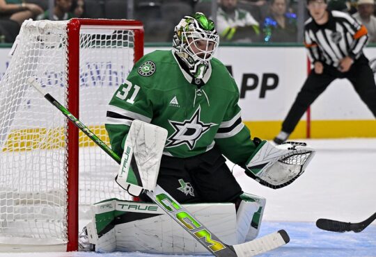 Dallas Stars goaltender Rémi Poirier crouches in his crease beside the net, eyeing the play.