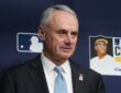 Major League Baseball commissioner Rob Manfred stands in front of an MLB backdrop before a World Series game.