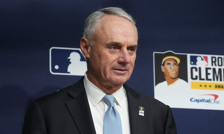 Major League Baseball commissioner Rob Manfred stands in front of an MLB backdrop before a World Series game.