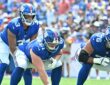 New York Giants quarterback Russell Wilson, No. 3, stands behind center John Michael Schmitz Jr. at the line of scrimmage.