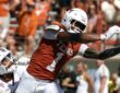 Texas Longhorns wide receiver Ryan Wingo, No. 1, stretches one hand toward the ball as a defender holds him.
