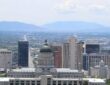 The Salt Lake City skyline with the Utah State Capitol dome and the Wasatch Range in the distance.