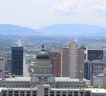 The Salt Lake City skyline with the Utah State Capitol dome and the Wasatch Range in the distance.