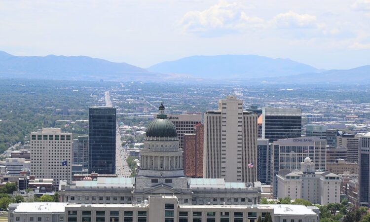 The Salt Lake City skyline with the Utah State Capitol dome and the Wasatch Range in the distance.