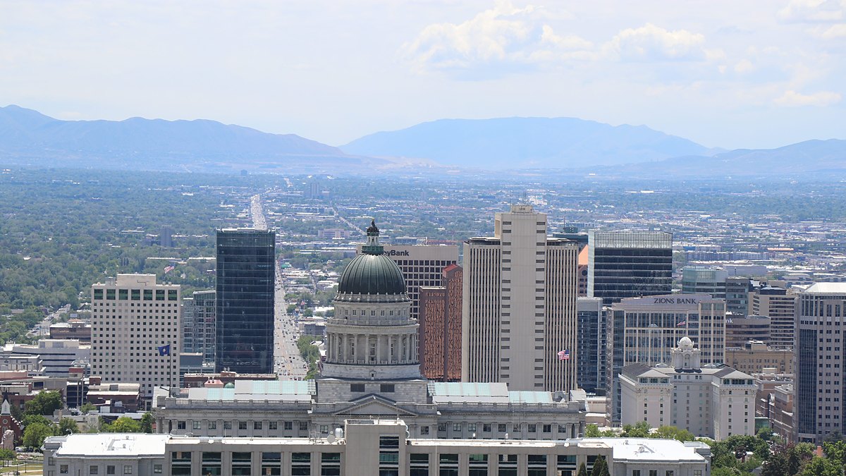The Salt Lake City skyline with the Utah State Capitol dome and the Wasatch Range in the distance.