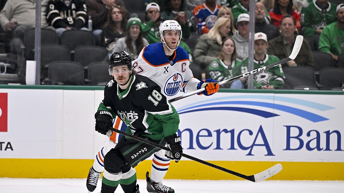 Stars center Sam Steel and Oilers center Connor McDavid skate side by side as both look up for the puck.