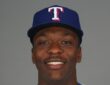 Texas Rangers infield prospect Sebastian Walcott poses in a cap and jersey during media day.