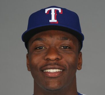 Texas Rangers infield prospect Sebastian Walcott poses in a cap and jersey during media day.