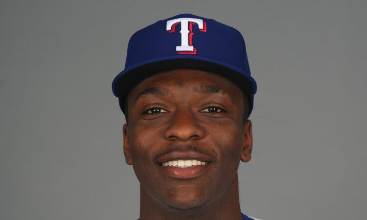 Texas Rangers infield prospect Sebastian Walcott poses in a cap and jersey during media day.