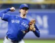 Toronto Blue Jays starting pitcher Shane Bieber rears back to throw a pitch from the mound in his road uniform.