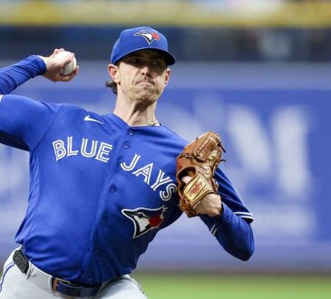 Toronto Blue Jays starting pitcher Shane Bieber rears back to throw a pitch from the mound in his road uniform.