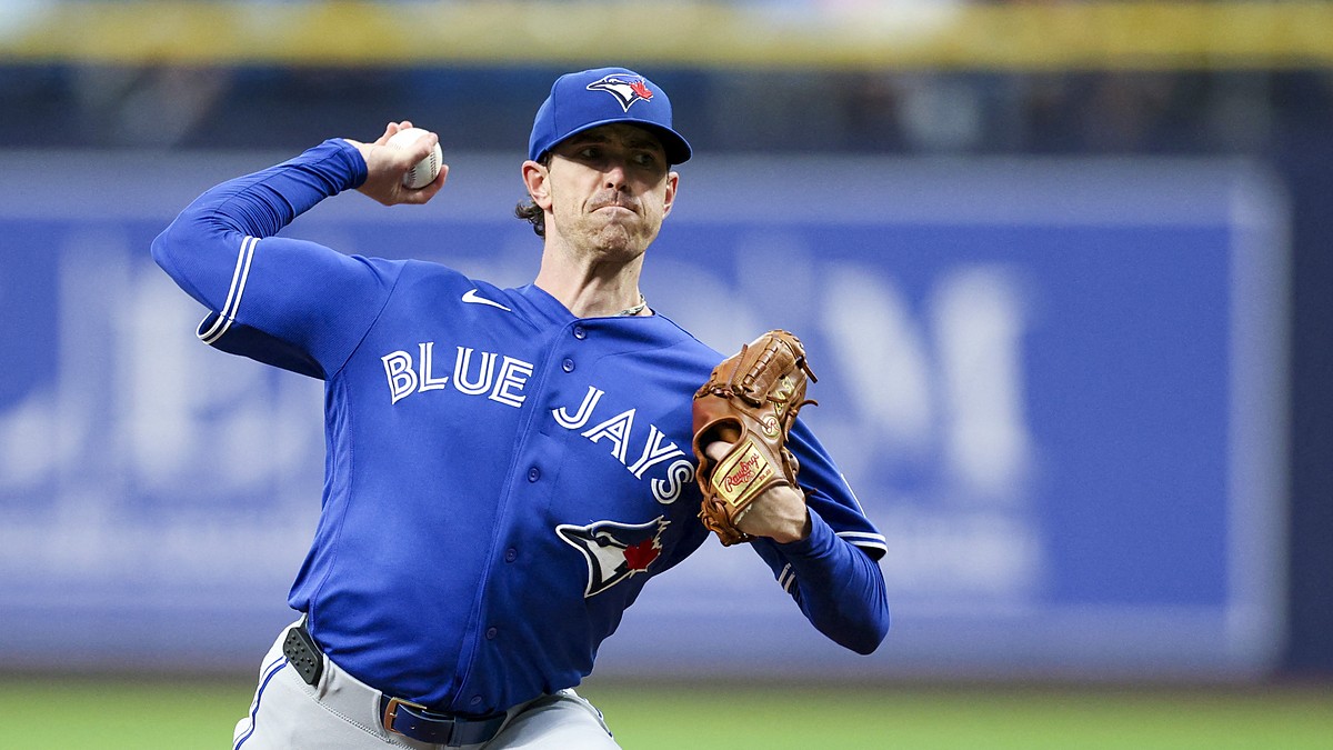 Toronto Blue Jays starting pitcher Shane Bieber rears back to throw a pitch from the mound in his road uniform.