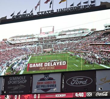A stadium videoboard reads Game Delayed, Power Outage above a kickoff countdown before SMU plays Florida State.