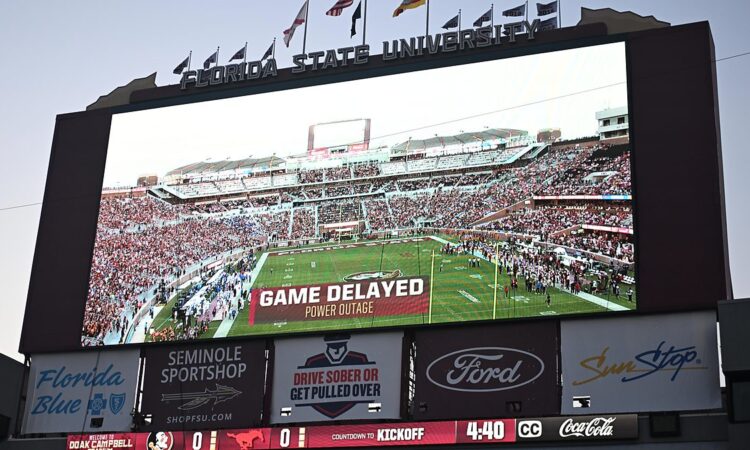 A stadium videoboard reads Game Delayed, Power Outage above a kickoff countdown before SMU plays Florida State.