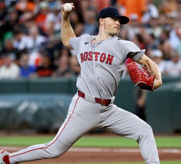 Red Sox pitcher Sonny Gray strides toward the plate mid-delivery with the ball in his raised right hand.