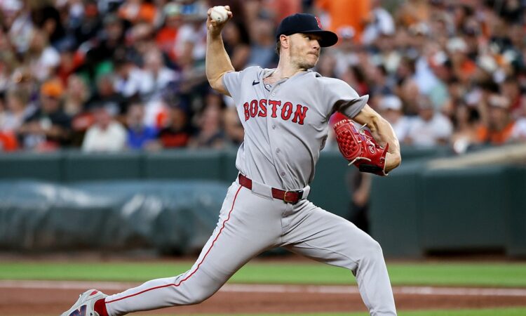 Red Sox pitcher Sonny Gray strides toward the plate mid-delivery with the ball in his raised right hand.