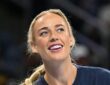 Indiana Fever guard Sophie Cunningham smiles and looks upward while warming up in a navy T-shirt.