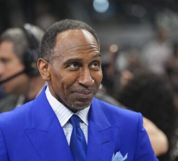 ESPN commentator Stephen A. Smith stands courtside in a blue suit before an NBA Finals game.