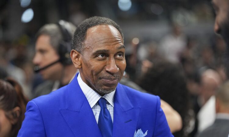 ESPN commentator Stephen A. Smith stands courtside in a blue suit before an NBA Finals game.
