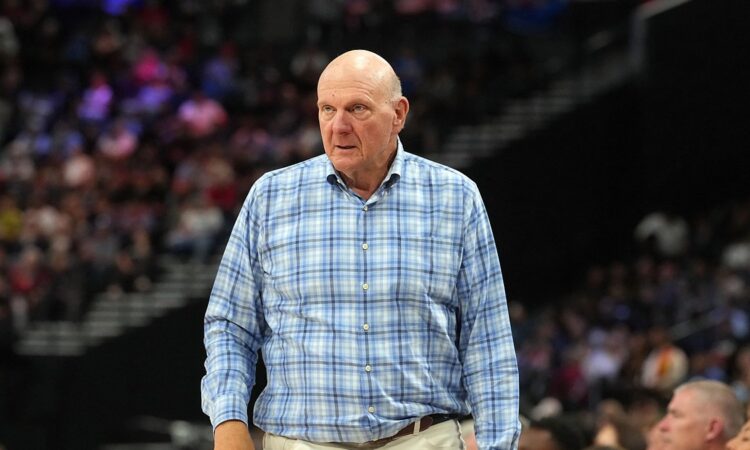 Clippers owner Steve Ballmer stands courtside in a plaid shirt watching the game against the Spurs.