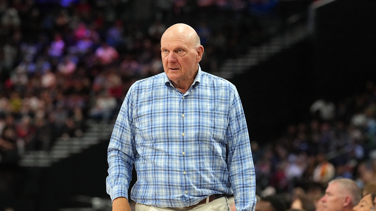 Clippers owner Steve Ballmer stands courtside in a plaid shirt watching the game against the Spurs.