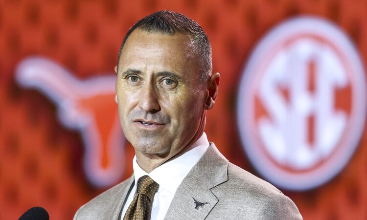 Texas Longhorns head coach Steve Sarkisian speaks in front of a Longhorns and SEC backdrop at media days.