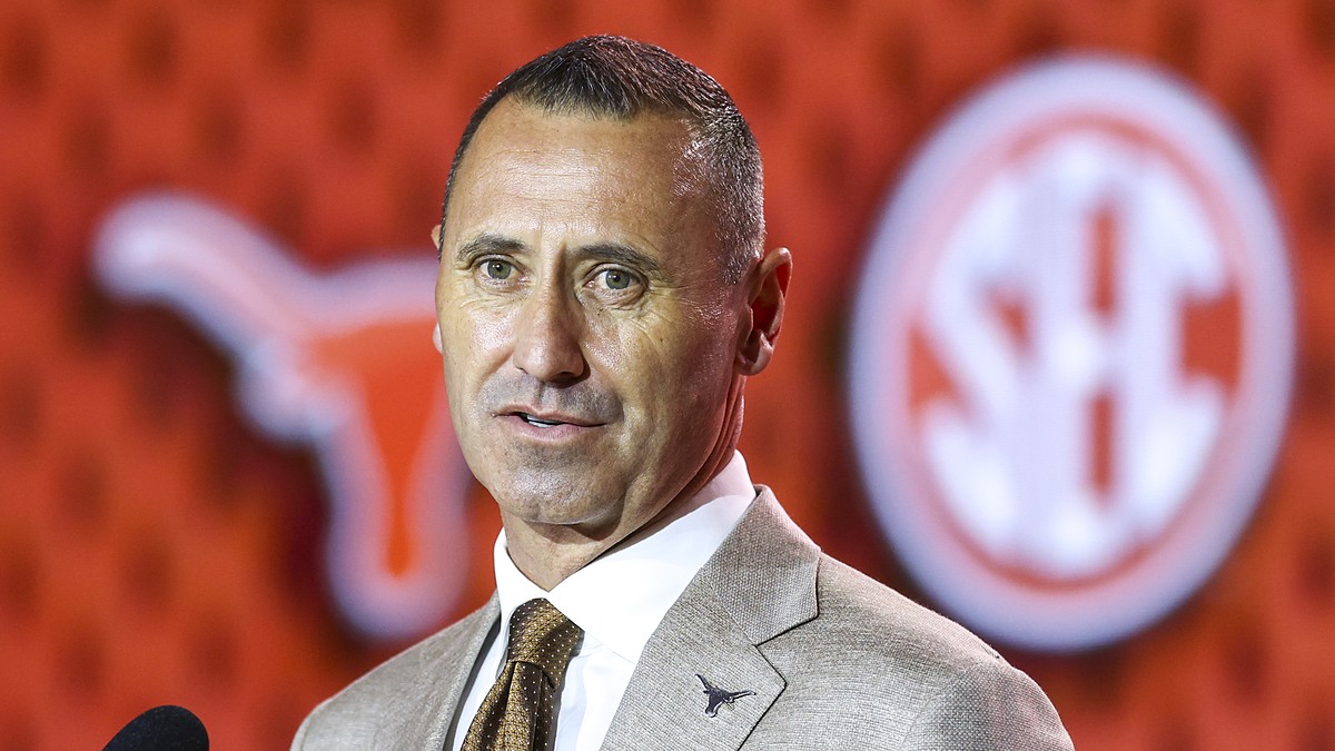 Texas Longhorns head coach Steve Sarkisian speaks in front of a Longhorns and SEC backdrop at media days.