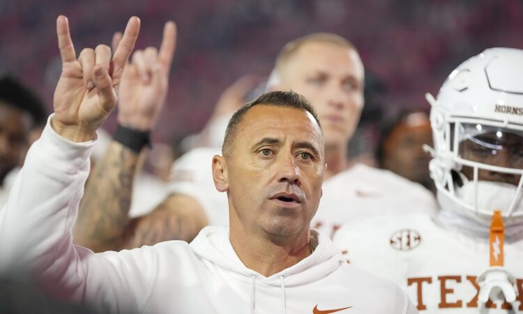 Texas Longhorns head coach Steve Sarkisian raises the Hook ’em Horns hand sign after the game against Georgia.