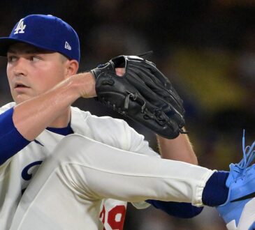 Los Angeles Dodgers starting pitcher Tarik Skubal lifts his leg high with his glove at his chin during his delivery.