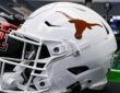 A white Texas Longhorns football helmet sits on a table with a Texas Tech helmet behind it at AT&T Stadium.