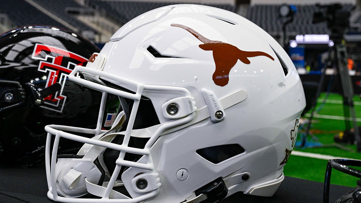 A white Texas Longhorns football helmet sits on a table with a Texas Tech helmet behind it at AT&T Stadium.