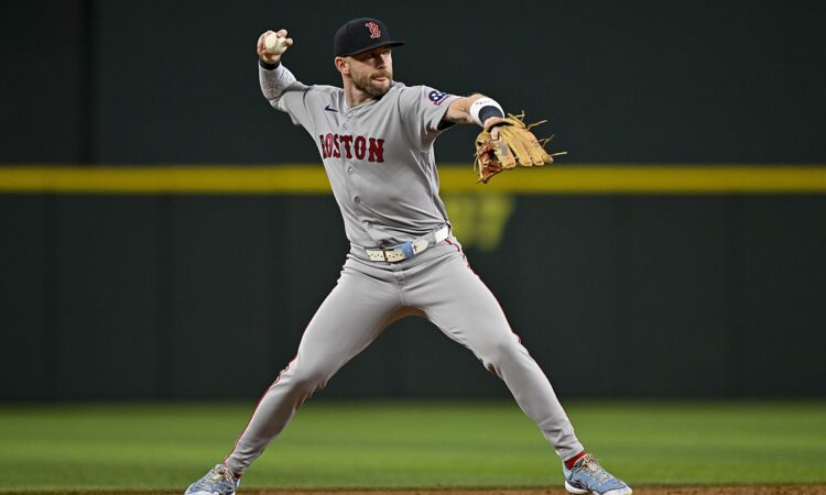 Boston Red Sox shortstop Trevor Story sets his feet and throws to first base during a game at Globe Life Field.