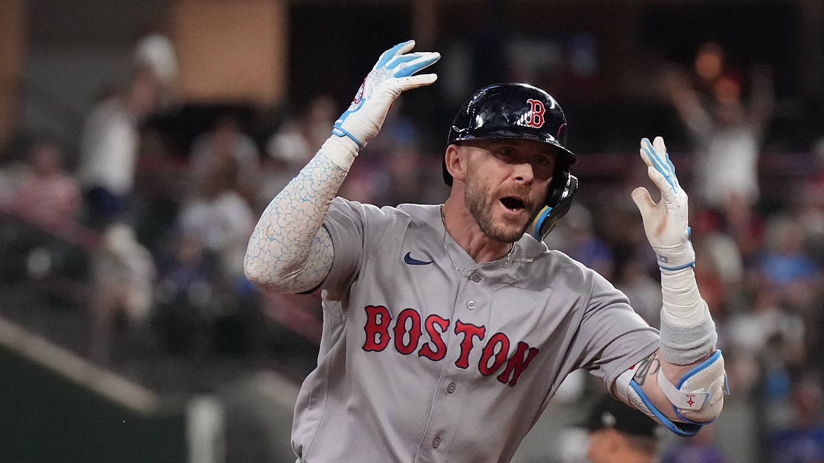Boston Red Sox shortstop Trevor Story throws both hands up and shouts as he rounds the bases after a home run.