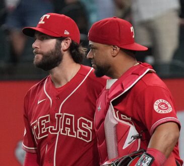Texas Rangers pitcher Trevor Williams and catcher Elias Díaz walk off the field side by side after a win.