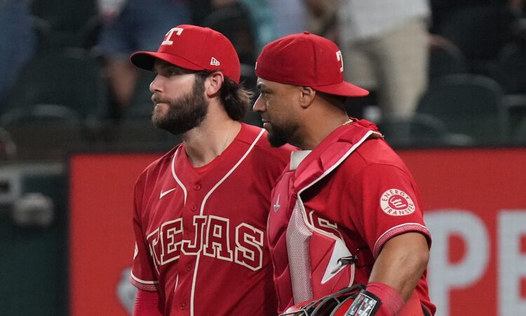 Texas Rangers pitcher Trevor Williams and catcher Elias Díaz walk off the field side by side after a win.