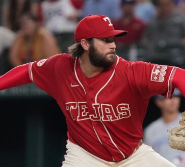 Texas Rangers pitcher Trevor Williams, in a red Tejas jersey, rears back to throw a pitch from the mound.