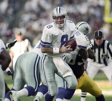 Dallas Cowboys quarterback Troy Aikman turns with the ball to hand off to running back Emmitt Smith against the Steelers.