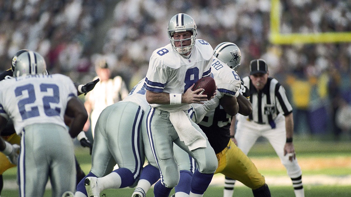 Dallas Cowboys quarterback Troy Aikman turns with the ball to hand off to running back Emmitt Smith against the Steelers.