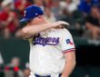 Texas Rangers relief pitcher Tyler Alexander wipes his face with his arm as he walks off the field.