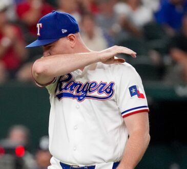 Texas Rangers relief pitcher Tyler Alexander wipes his face with his arm as he walks off the field.