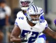 Dallas Cowboys guard Tyler Booker sets up to block with the quarterback standing behind him.