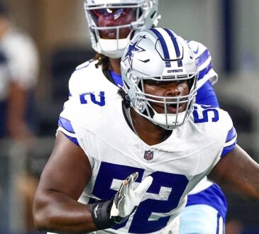 Dallas Cowboys guard Tyler Booker sets up to block with the quarterback standing behind him.