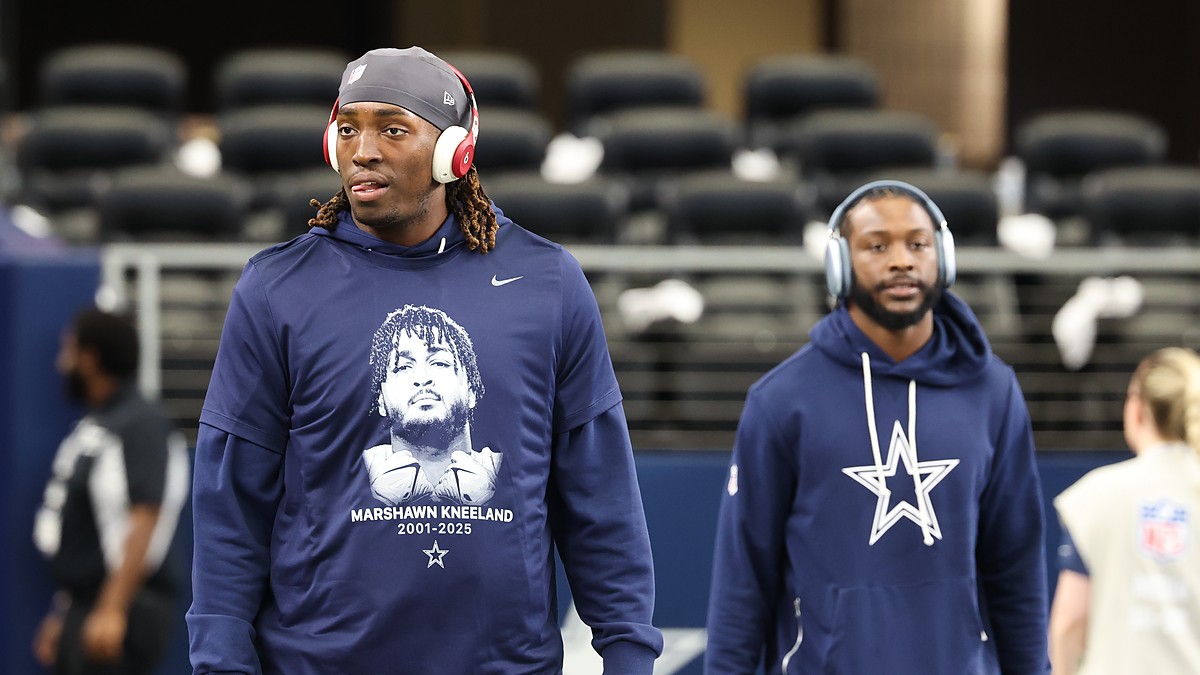 A Dallas Cowboys player in a memorial shirt honoring Marshawn Kneeland walks the field before the game against the Eagles.
