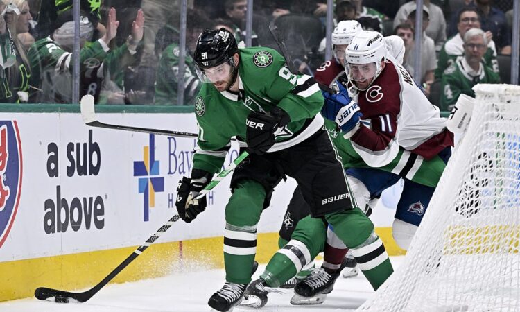 Dallas Stars center Tyler Seguin shields the puck near the net as Colorado's Brock Nelson pressures him.