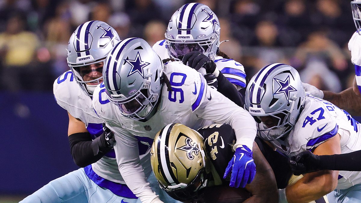 Dallas Cowboys linebacker Tyrus Wheat wraps up New Orleans Saints running back CJ Donaldson as teammates converge.