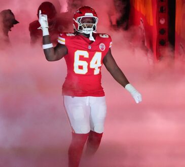 Kansas City Chiefs offensive tackle Wanya Morris raises a hand as he is introduced through smoke at Arrowhead Stadium.
