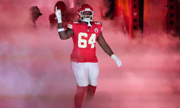 Kansas City Chiefs offensive tackle Wanya Morris raises a hand as he is introduced through smoke at Arrowhead Stadium.