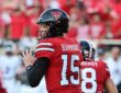 Texas Tech quarterback Will Hammond, No. 15, cocks the ball to pass with a teammate in front of him.