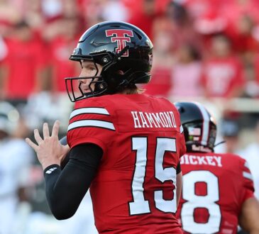 Texas Tech quarterback Will Hammond, No. 15, cocks the ball to pass with a teammate in front of him.
